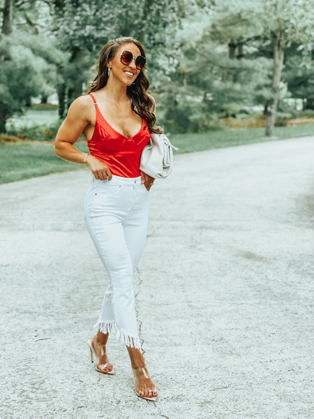 woman wearing white jeans and red bodysuit