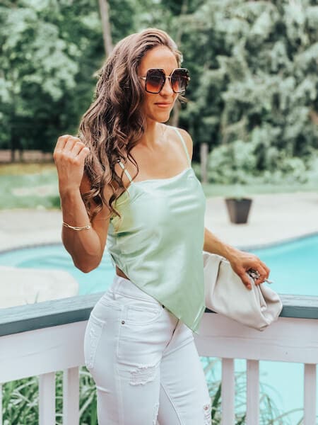 woman wearing white jeans with silky tie back top